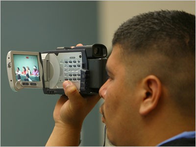 Ethnographer Roger Lara double-checks his aim as he takes video footage of the parent participants during a seminar lecture session. Ethnographer Roger Lara double-checks his aim as he takes video footage of the parent participants during a seminar lecture session.